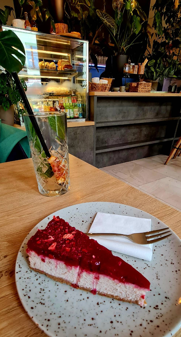 Interiér kavárny s rostlinami a dezerty ve vitríně